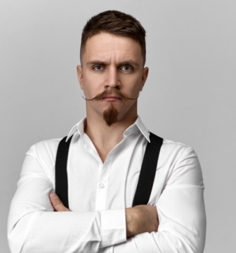 stylish-confident-bearded-boss-suspenders-white-shirt-posing-isolated-blank-copyspace-studio-wall